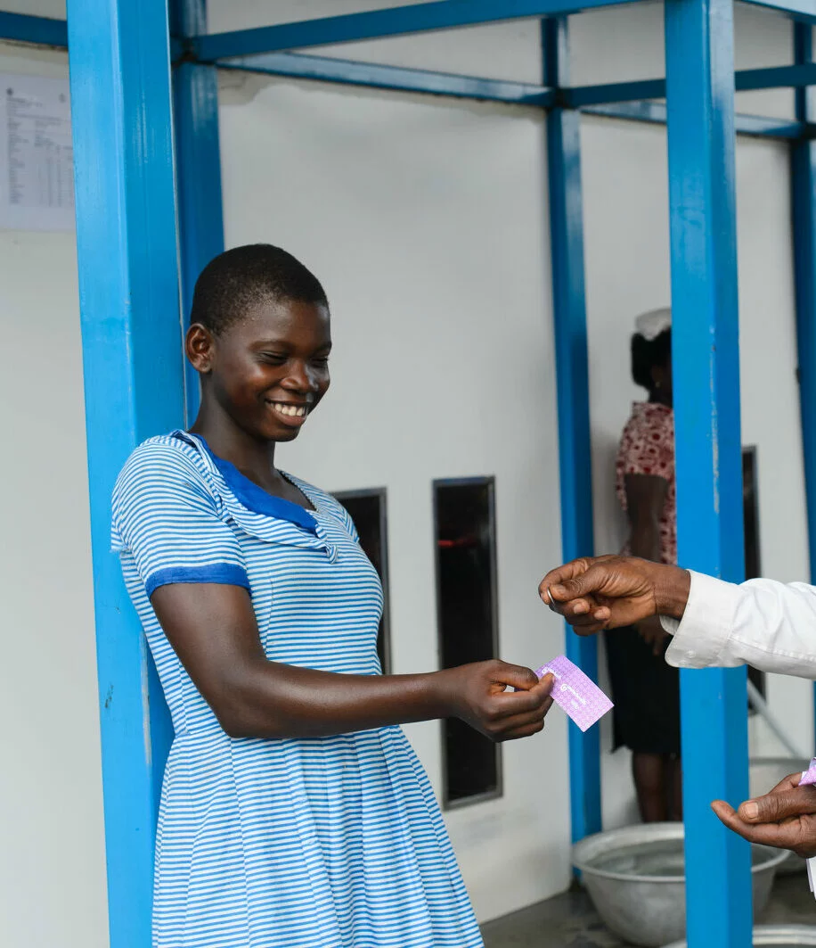 Mary Kpodo (14) buying water coupons from Christian Gblekpo, a coupon vendor, at a Safe Water Network water centre in Dzemeni in the Volta Region of Ghana on 23 October 2012. 2024/08/20121023_DSC_5971-e1724874766702.jpg 