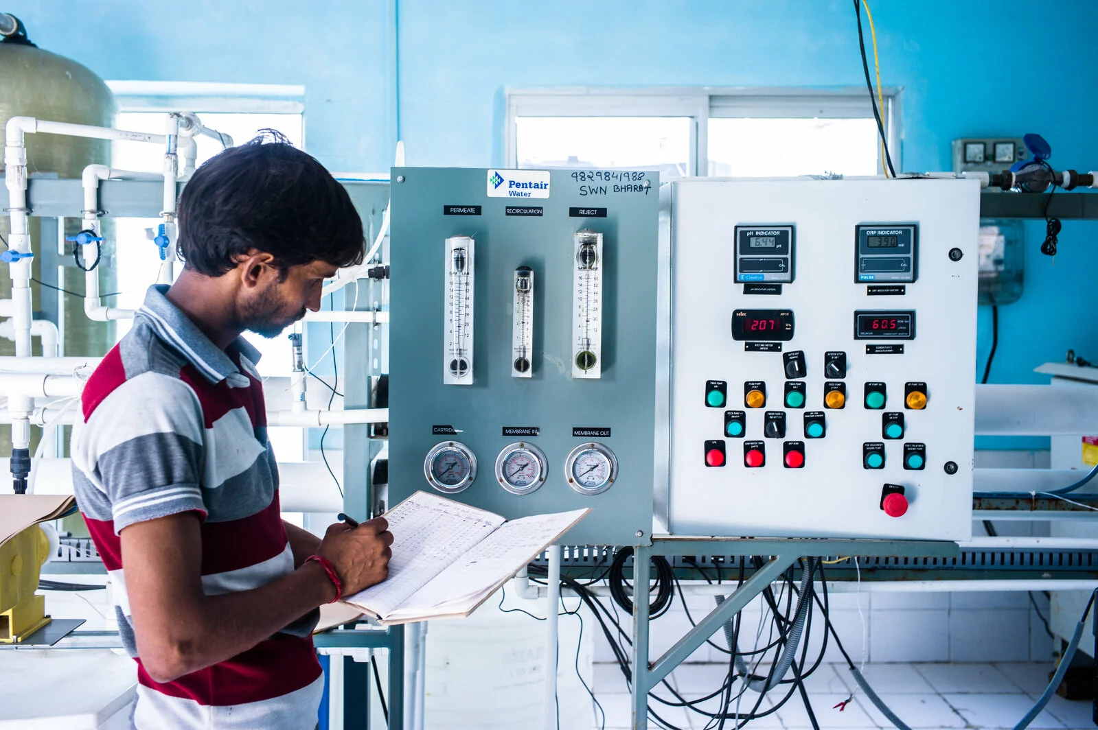 Nirjay Kumar, the entrepreneur and plant operator illustrates the step-by-step water purification process at the water purification station in Kureb village in Jewar of Gautam Buddha district of Uttar Pradesh, India. Photograph: Sanjit Das/Panos for Safe Water Network 2024/10/sdas20120930-safe_water_network-india-504.jpg 